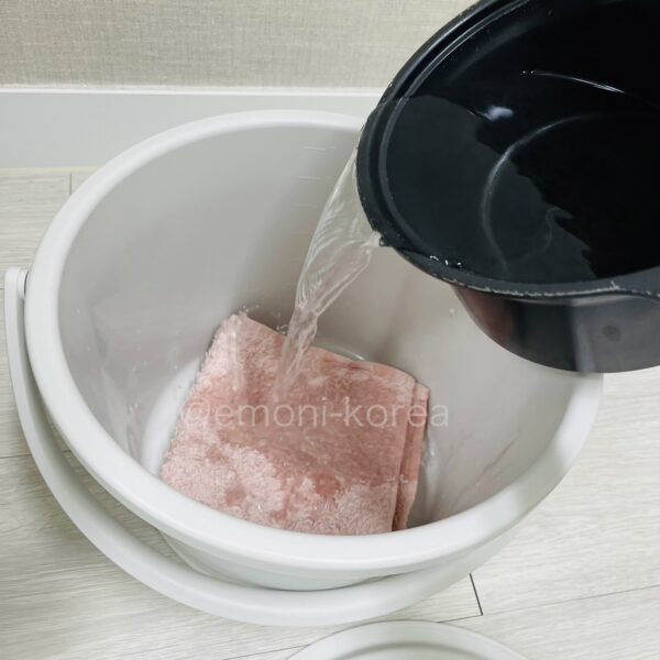 ジーパンの生乾き臭をなくすためにタオルの入ったバケツに熱湯を注いでいる写真