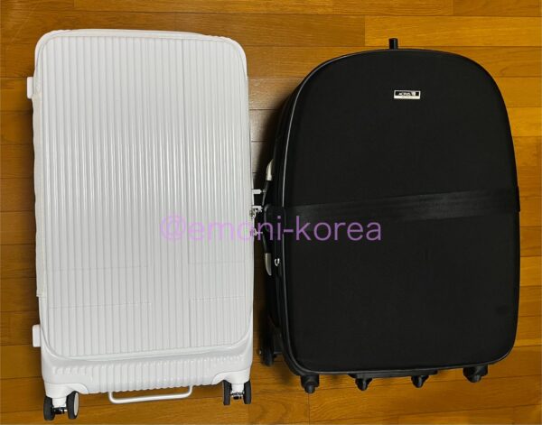 以前使っていた黒い布製のスーツケースと新しい白色のスーツケース