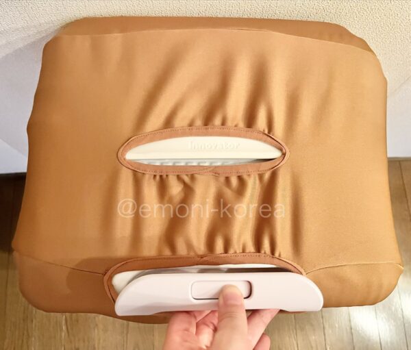 イノベーターINV650DORにキャメル色のスーツケースカバーを実際に装着し上から見た、持ち手を引き出している写真